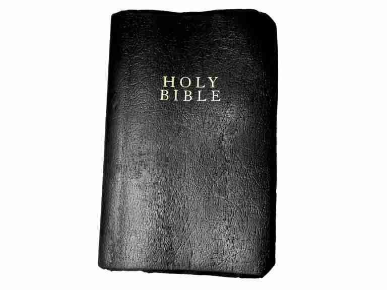 A black-covered holy bible, prompting the question "When was the last time you read the Bible?" lying on a plain background.